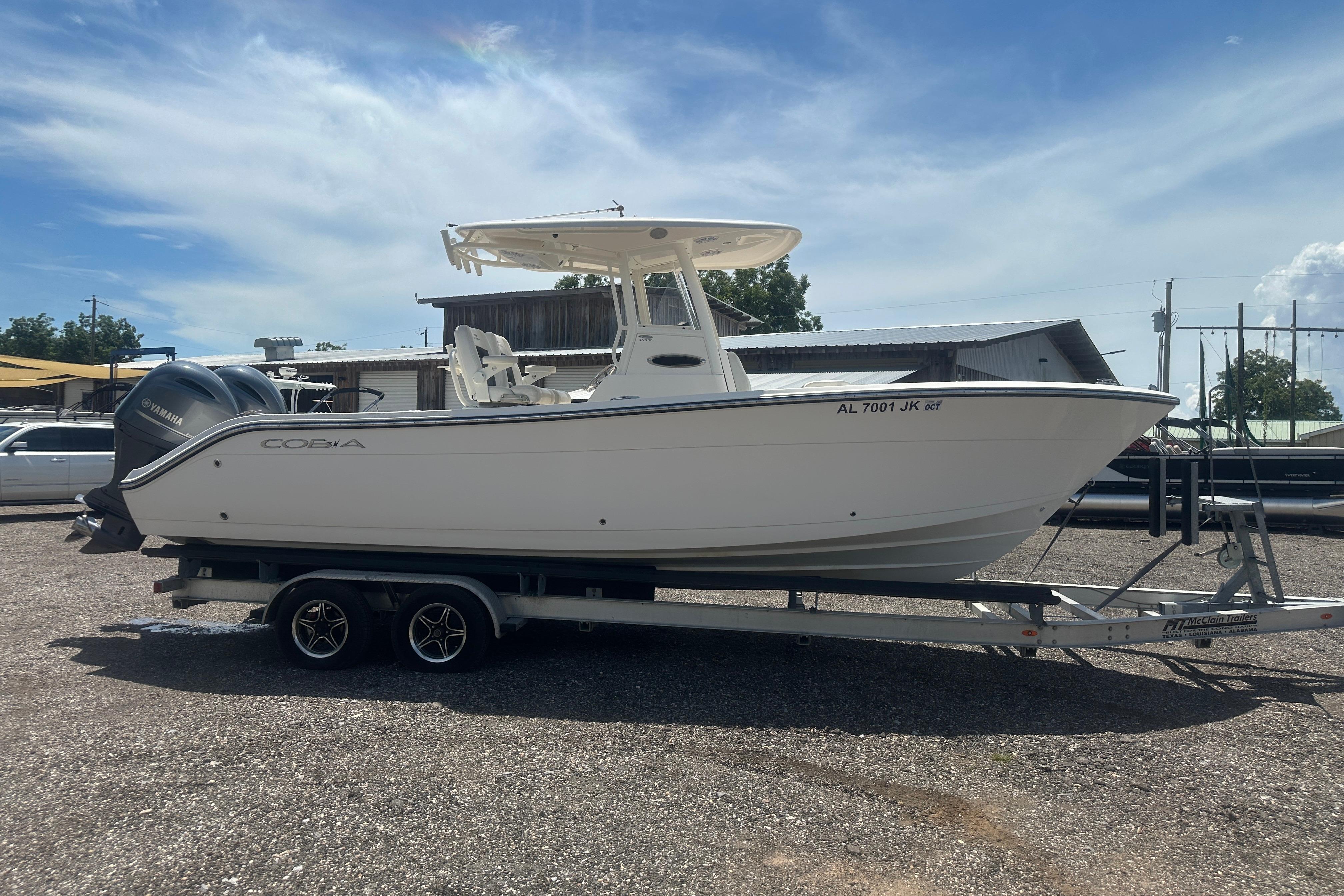 2023 Cobia 262 Center Console boat on trailer, parked outdoors under clear sky.