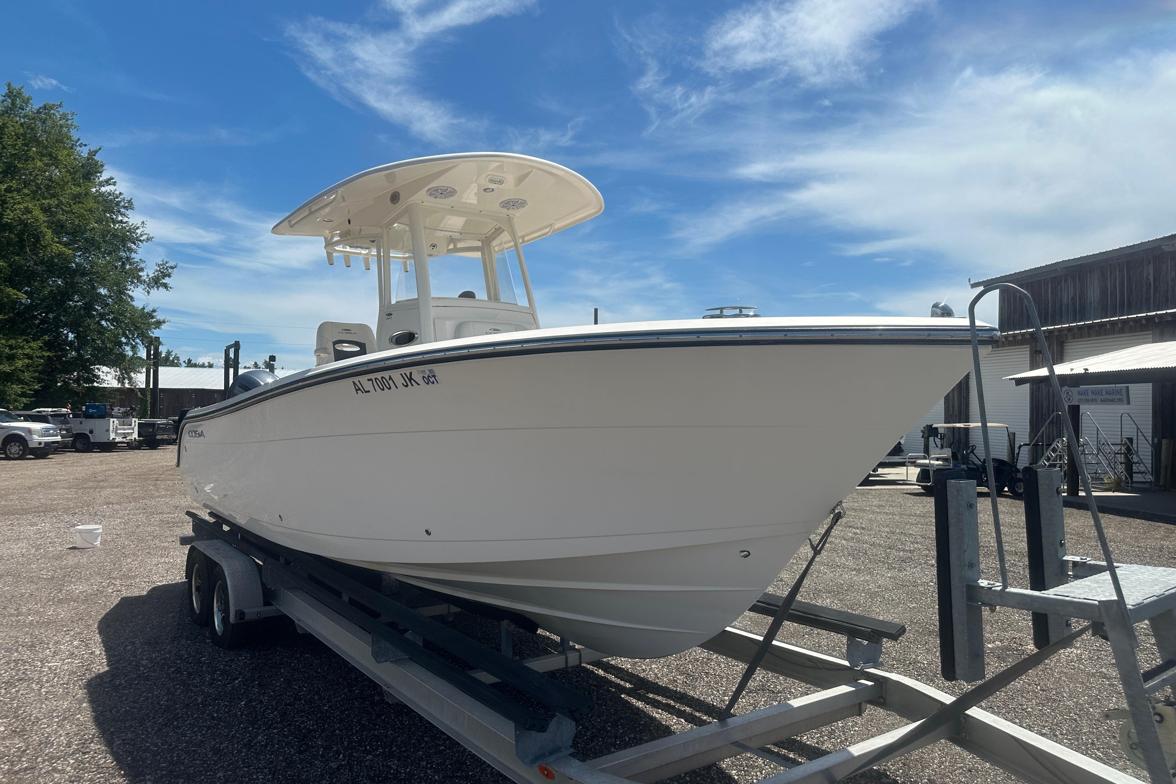 2023 Cobia 262 Center Console boat on trailer under clear blue sky.