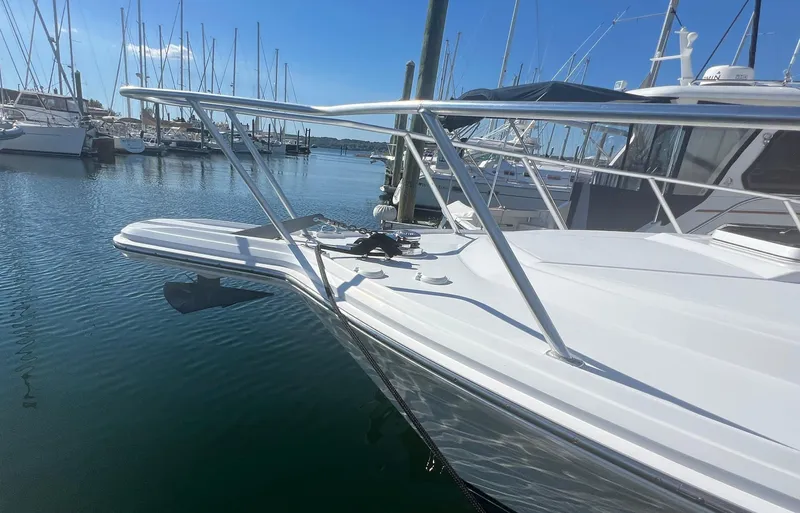 Dog Daze Yacht Photos Pics 2001 Jupiter 35 Convertible boat docked in a marina, surrounded by sailboats.