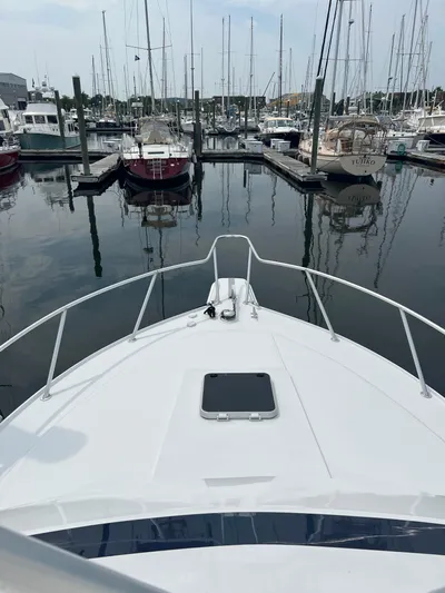 Dog Daze Yacht Photos Pics Bow view of a 2001 Jupiter 35 Convertible yacht docked in a marina.