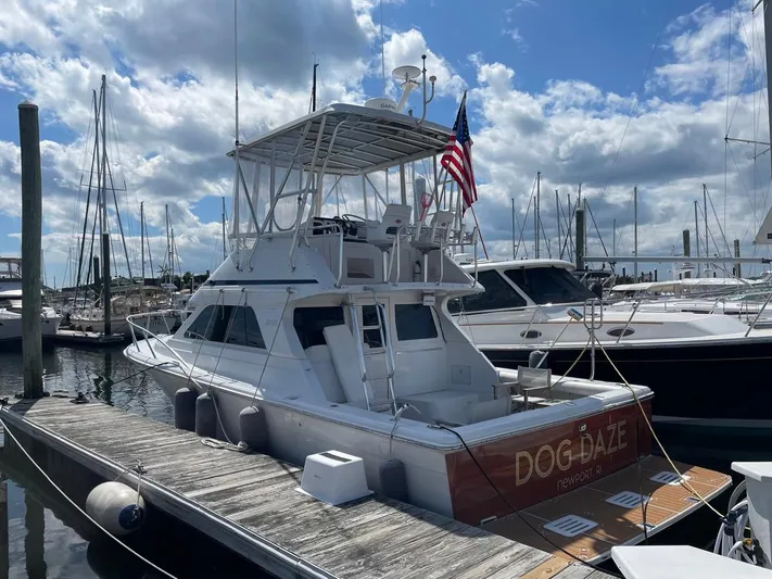 Dog Daze Yacht Photos Pics 2001 Jupiter 35 Convertible yacht docked at marina under cloudy sky.