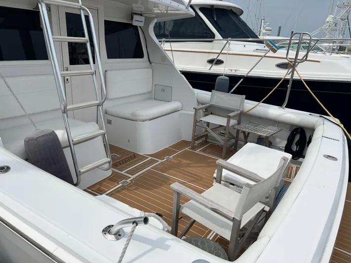 Dog Daze Yacht Photos Pics 2001 Jupiter 35 Convertible yacht deck with seating and ladder, docked at marina.