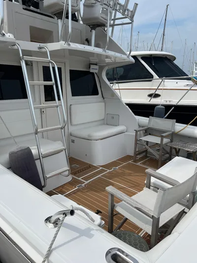 Dog Daze Yacht Photos Pics 2001 Jupiter 35 Convertible yacht with seating and ladder in marina setting.