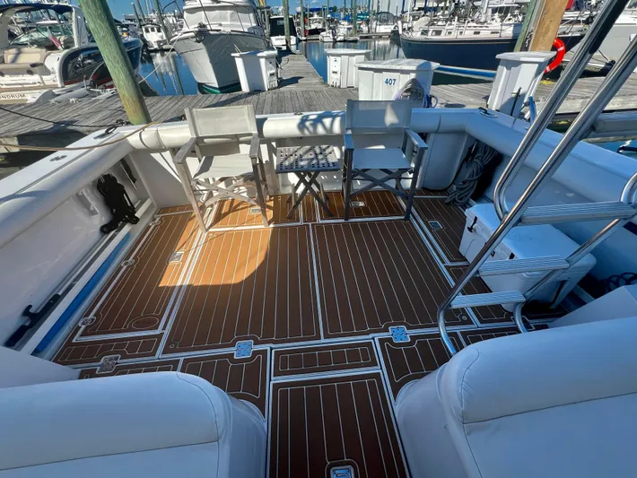 Dog Daze Yacht Photos Pics Deck of 2001 Jupiter 35 Convertible boat with wooden flooring and seating at marina.