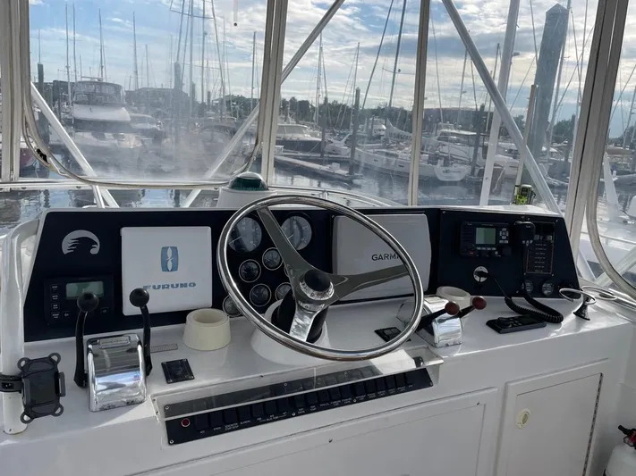 Dog Daze Yacht Photos Pics Helm of 2001 Jupiter 35 Convertible boat with navigation equipment and marina view.