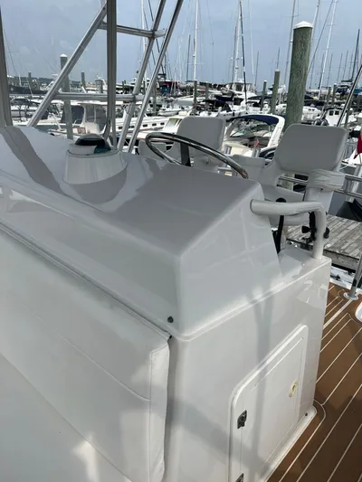 Dog Daze Yacht Photos Pics Helm of 2001 Jupiter 35 Convertible yacht at marina, featuring steering wheel and seating.