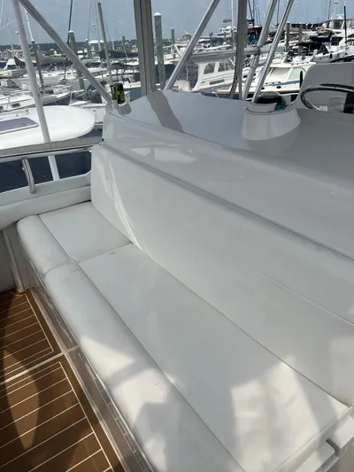 Dog Daze Yacht Photos Pics White seating area on a 2001 Jupiter 35 Convertible yacht, docked at a marina.