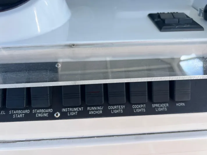 Dog Daze Yacht Photos Pics Control panel of a 2001 Jupiter 35 Convertible boat with labeled switches.