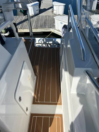 Dog Daze Yacht Photos Pics Deck view of 2001 Jupiter 35 Convertible boat at dock, featuring teak flooring and stainless steel railings.