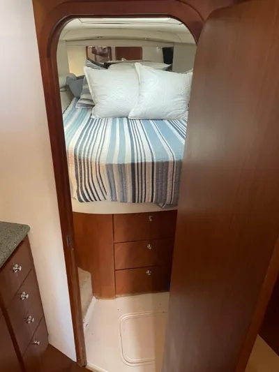 Dog Daze Yacht Photos Pics Interior cabin of 2001 Jupiter 35 Convertible yacht with bed and wooden cabinetry.