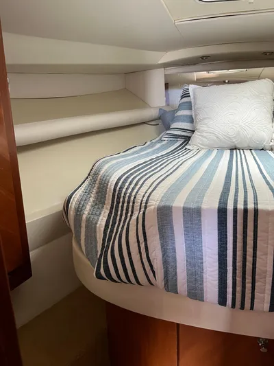 Dog Daze Yacht Photos Pics Cozy cabin interior of 2001 Jupiter 35 Convertible with striped bedding and pillows.