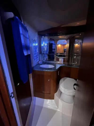 Dog Daze Yacht Photos Pics Compact bathroom in a 2001 Jupiter 35 Convertible boat, featuring wood cabinetry and modern fixtures.