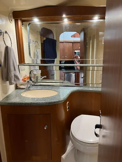 Dog Daze Yacht Photos Pics Bathroom interior of 2001 Jupiter 35 Convertible yacht with sink and toilet.