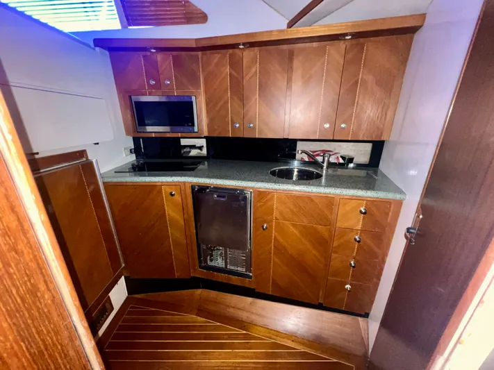 Dog Daze Yacht Photos Pics Luxurious wooden kitchen interior of 2001 Jupiter 35 Convertible yacht.
