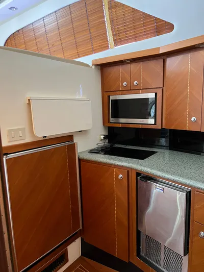 Dog Daze Yacht Photos Pics Luxurious kitchen interior of 2001 Jupiter 35 Convertible yacht with wood cabinets and modern appliances.