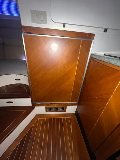 Dog Daze Yacht Photos Pics Interior of 2001 Jupiter 35 Convertible with wood paneling and flooring.