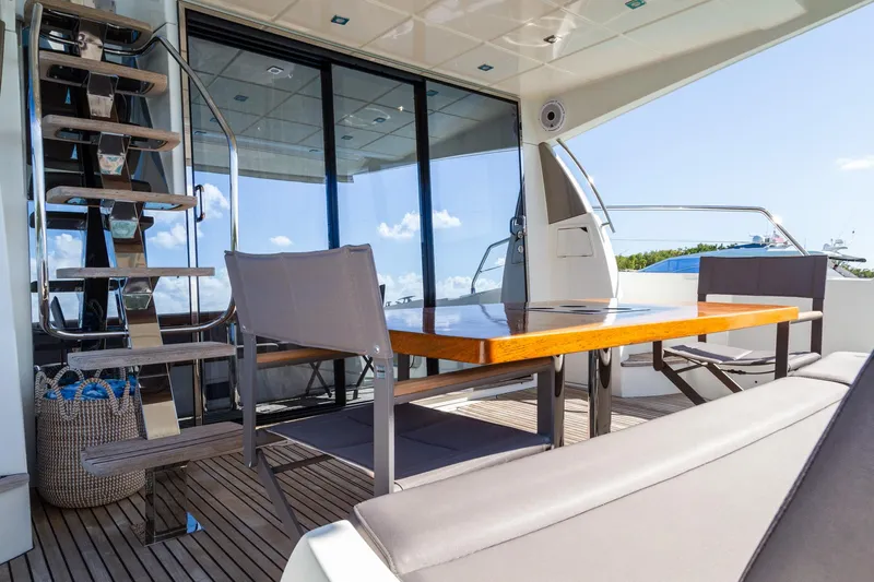 Yacht Photos Pics Prestige 560 Flybridge 2018 yacht deck with seating and table, featuring modern design.