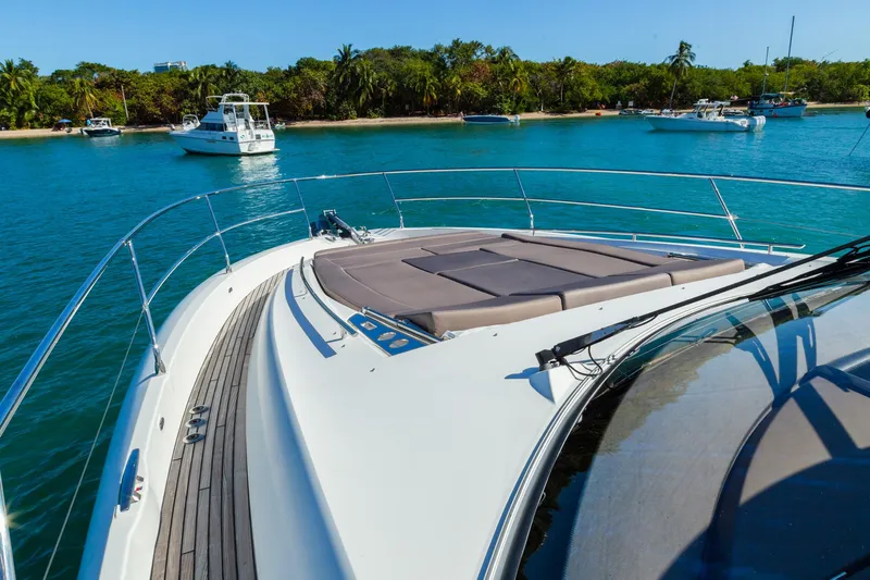  Yacht Photos Pics 2018 Prestige 560 Flybridge yacht on serene blue water near lush shoreline.