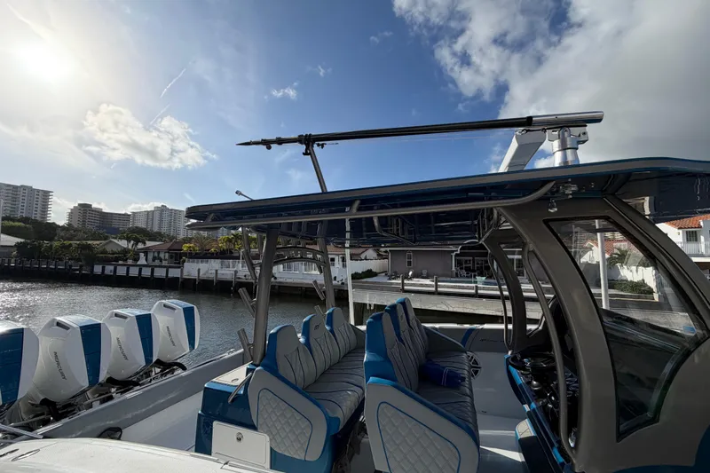  Yacht Photos Pics Midnight Express 43 Open boat with blue seating and multiple outboard engines docked by waterfront.