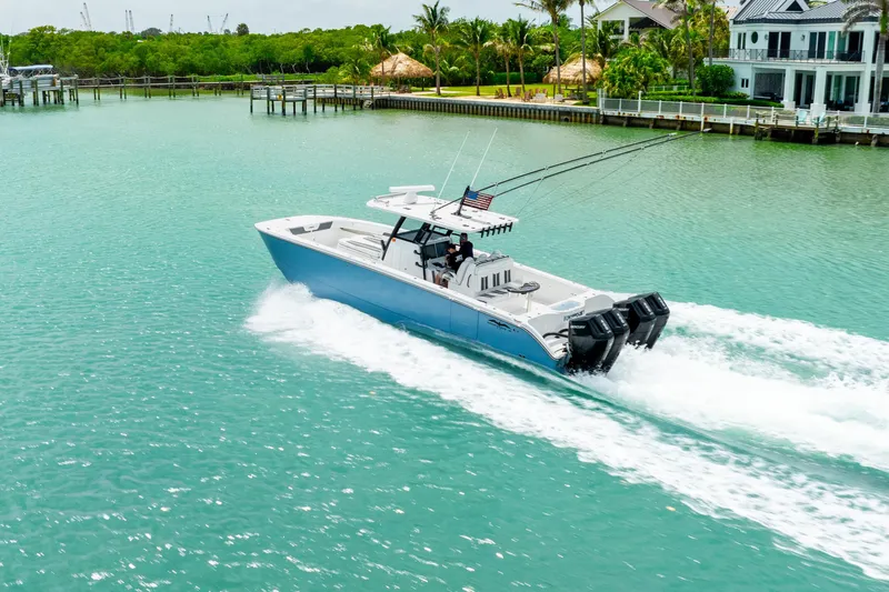 Kroppdustr Yacht Photos Pics 2023 Invincible 37 Catamaran cruising on turquoise water near a tropical shoreline.