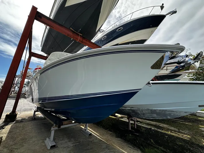  Yacht Photos Pics 2013 Contender 30 ST boat on dry dock, white hull with blue accents.