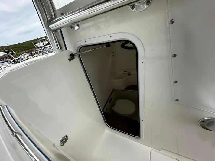  Yacht Photos Pics 2013 Contender 30 ST boat interior with open door revealing compact marine toilet.