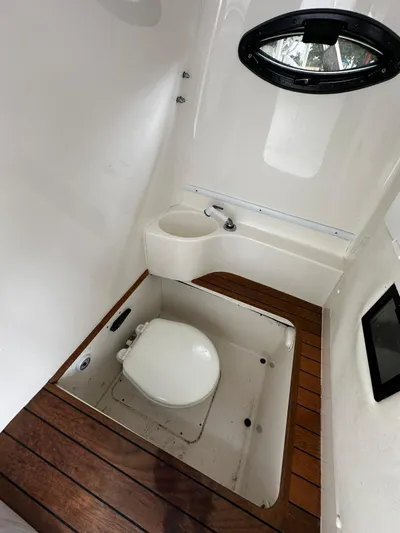  Yacht Photos Pics 2013 Contender 30 ST boat bathroom with wooden flooring and compact design.