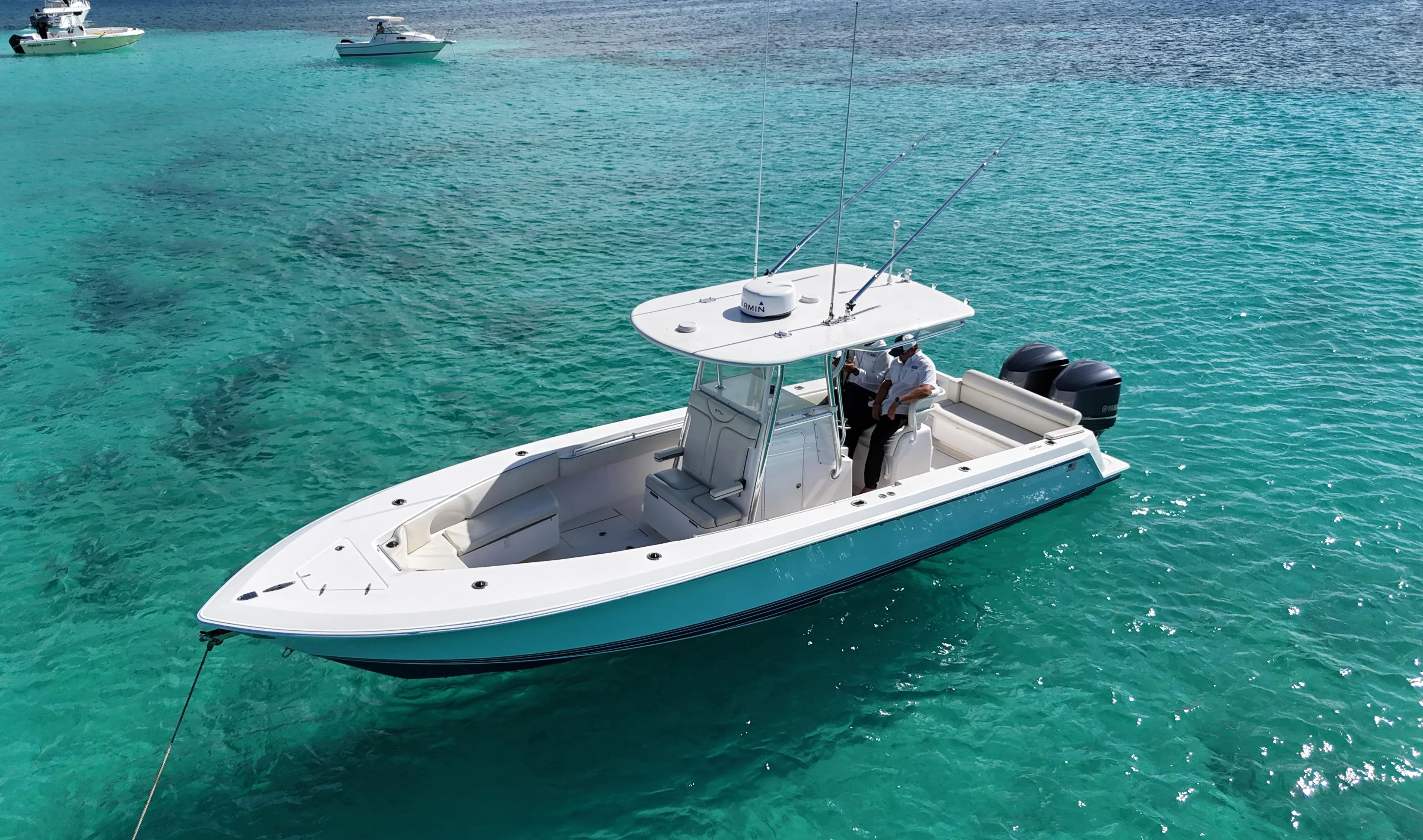 2013 Contender 30 ST boat on clear turquoise water, with two people onboard.