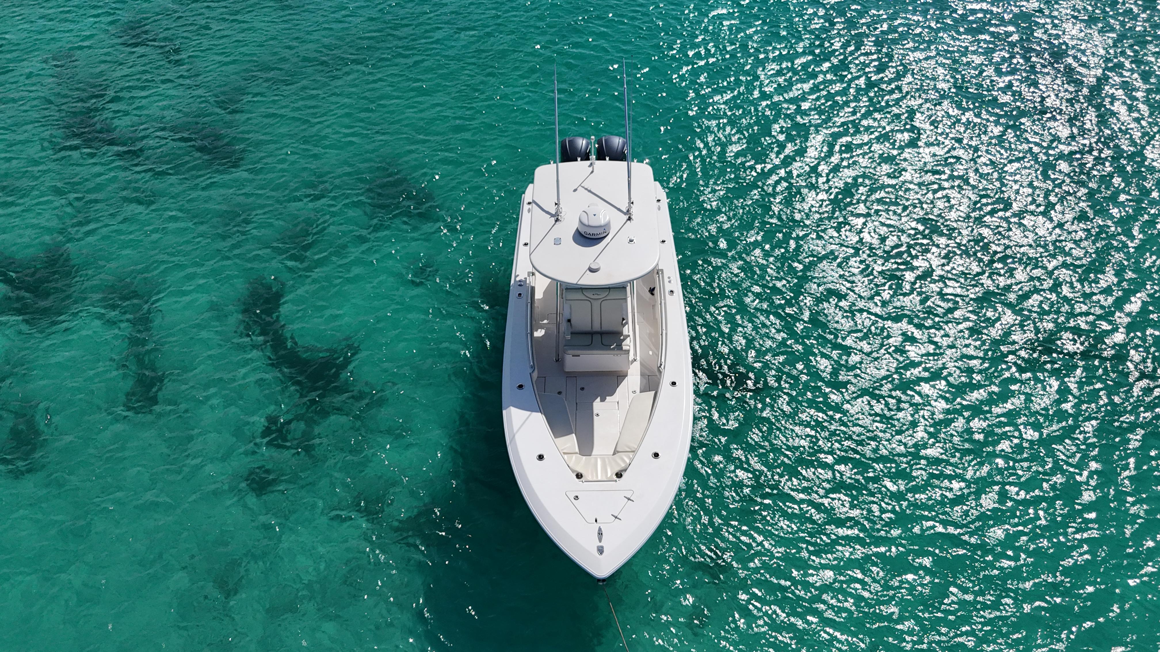 Aerial view of 2013 Contender 30 ST boat on clear turquoise water.
