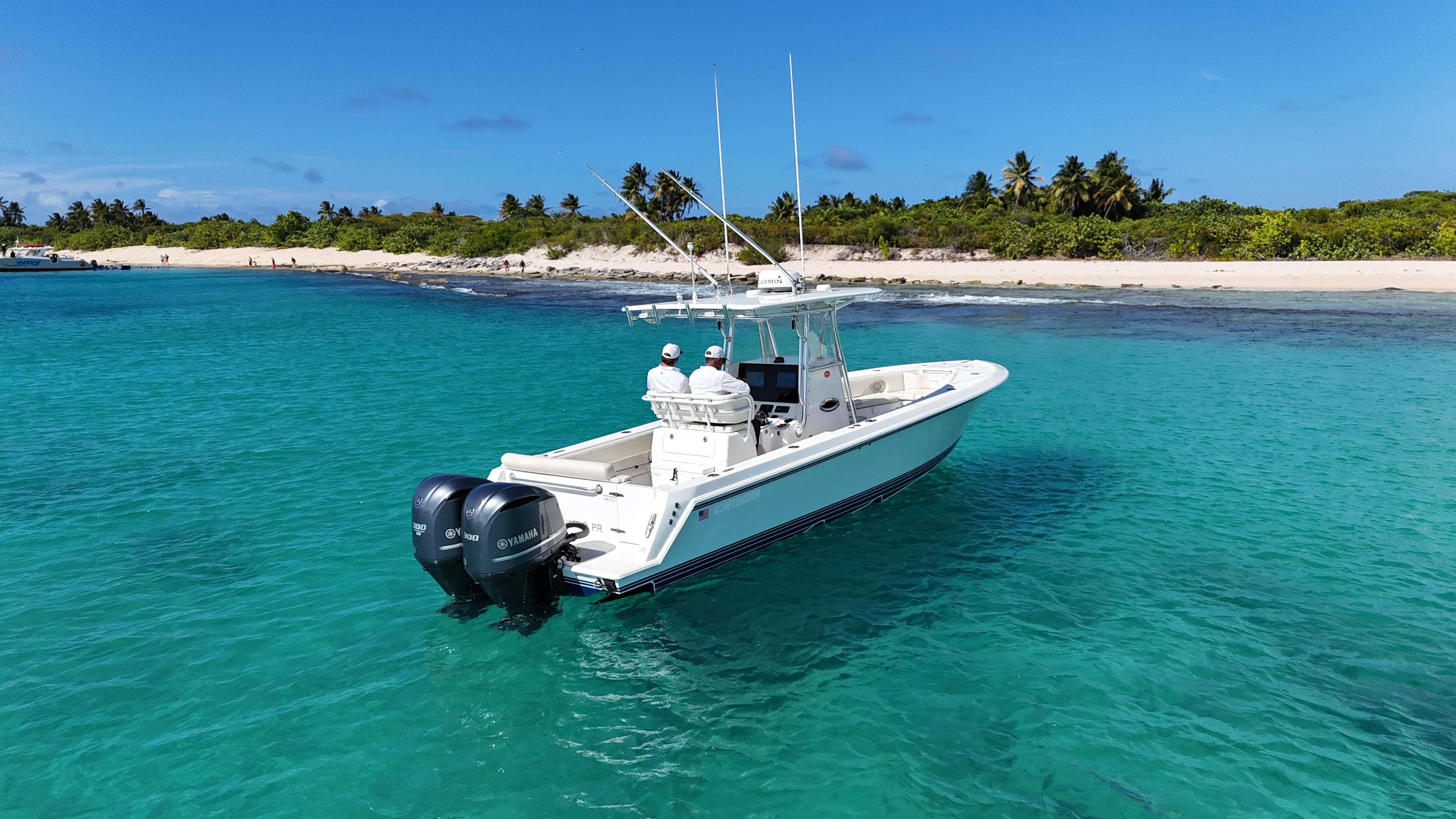 2013 Contender 30 ST boat in clear turquoise water near tropical beach.