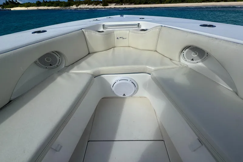  Yacht Photos Pics 2013 Contender 30 ST boat interior with cushioned seating and speakers, near a scenic shoreline.