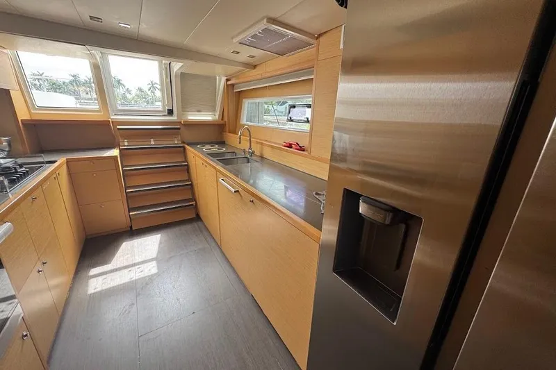 London Sky Yacht Photos Pics Modern kitchen interior on 2015 Lagoon Motor Yacht with stainless steel appliances and wooden cabinetry.