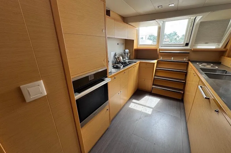 London Sky Yacht Photos Pics Modern kitchen interior on 2015 Lagoon Motor Yacht with wooden cabinetry and appliances.