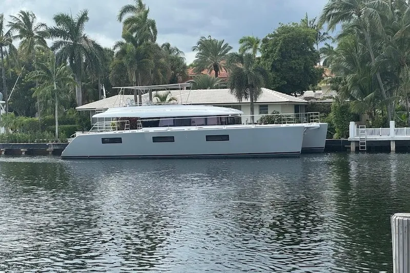 London Sky Yacht Photos Pics Lagoon 2015 motor yacht docked by palm trees and waterfront home.