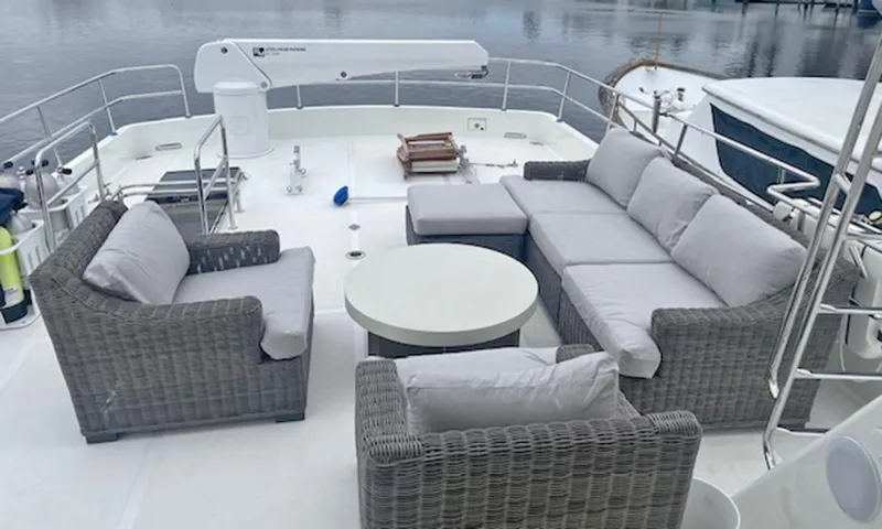 Our Way III Yacht Photos Pics Outdoor seating area on 2023 Outer Reef Yachts 720 Motoryacht, featuring wicker furniture and round table.