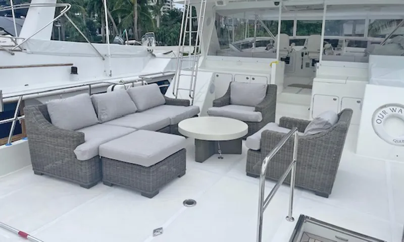 Our Way III Yacht Photos Pics Outdoor seating area on 2023 Outer Reef Yachts 720 Motoryacht, featuring gray wicker furniture.