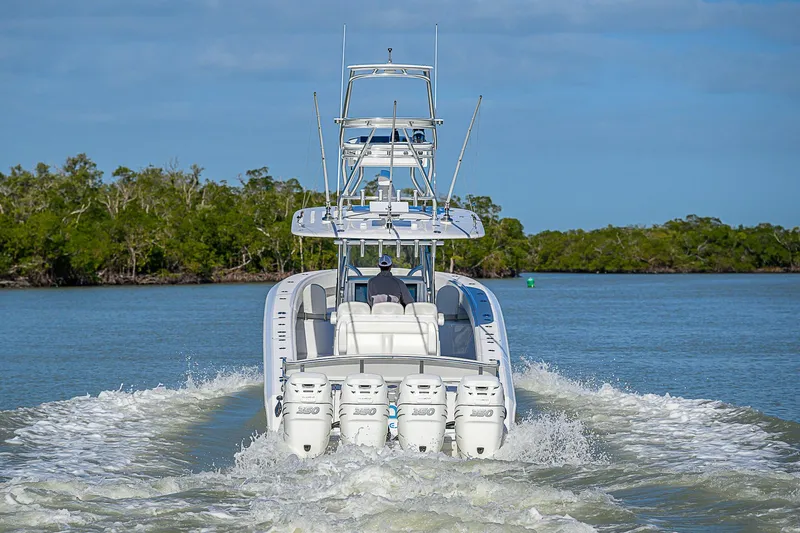Mare Yacht Photos Pics 2019 Bahama 41 boat cruising on a calm waterway with lush greenery.