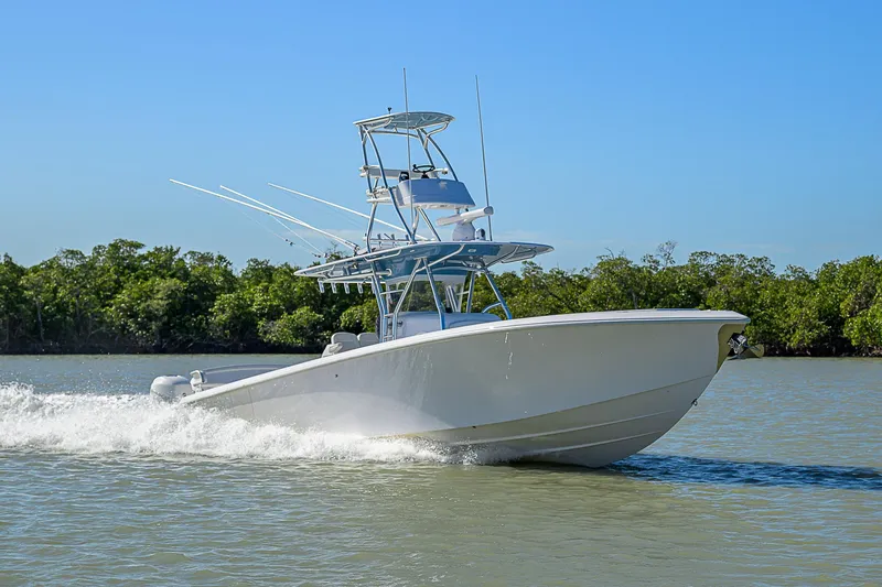 Mare Yacht Photos Pics 2019 Bahama 41 boat cruising on a sunny day, surrounded by lush greenery.