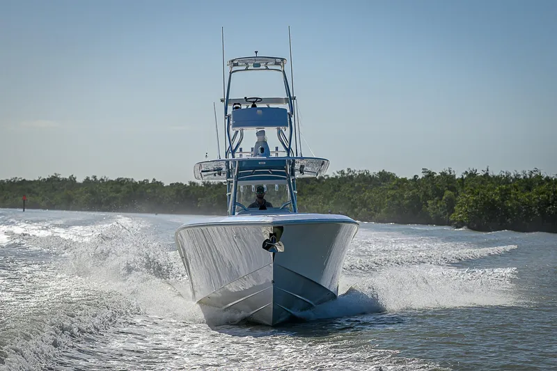 Mare Yacht Photos Pics 2019 Bahama 41 boat cruising on water, surrounded by lush greenery.