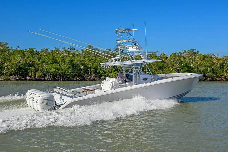 Mare Yacht Photos Pics 2019 Bahama 41 boat cruising on a sunny day, surrounded by lush greenery.