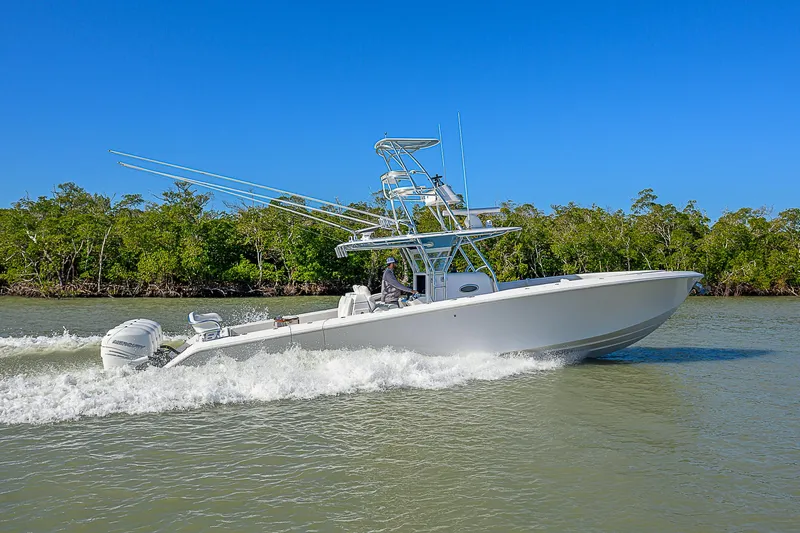 Mare Yacht Photos Pics 2019 Bahama 41 boat cruising on a river with lush green trees in the background.