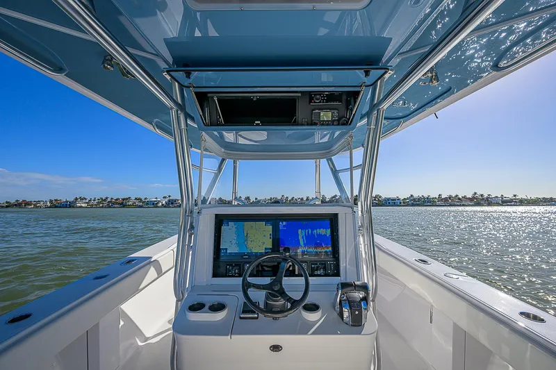 Mare Yacht Photos Pics 2019 Bahama 41 boat cockpit with navigation system, steering wheel, and ocean view.