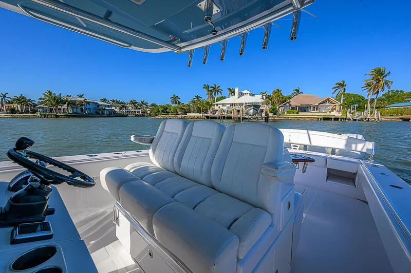 Mare Yacht Photos Pics 2019 Bahama 41 boat interior with white seating, steering wheel, and waterfront view.