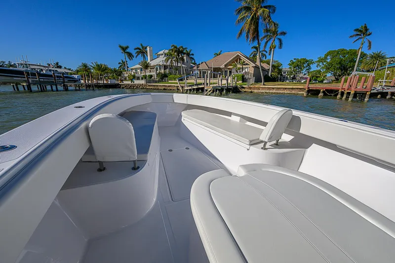 Mare Yacht Photos Pics 2019 Bahama 41 boat with sleek seating, docked near waterfront homes and palm trees.