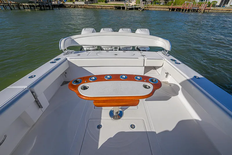 Mare Yacht Photos Pics 2019 Bahama 41 boat deck with fishing rod holders and seating, on calm water.
