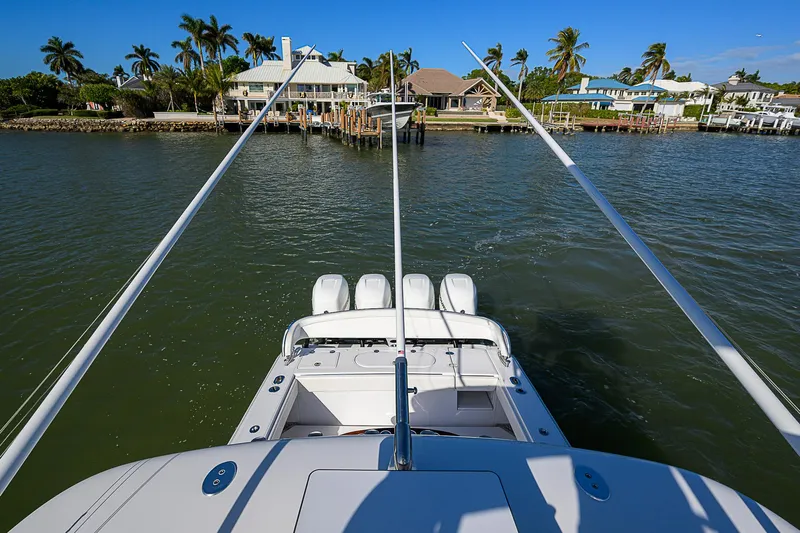 Mare Yacht Photos Pics 2019 Bahama 41 boat with multiple engines, docked near waterfront homes and palm trees.
