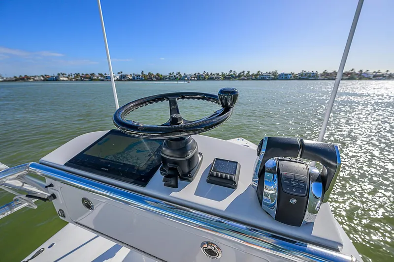 Mare Yacht Photos Pics Helm of 2019 Bahama 41 boat with steering wheel and controls, overlooking calm waters.