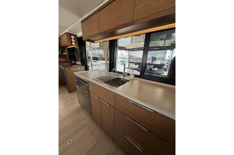  Yacht Photos Pics Modern kitchen interior of 2020 Lagoon 46 yacht with sleek wood cabinetry and stainless steel appliances.