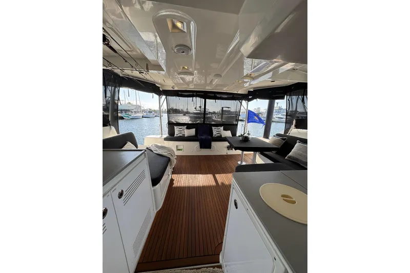  Yacht Photos Pics Interior view of 2020 Lagoon 46 catamaran with elegant seating and marina backdrop.