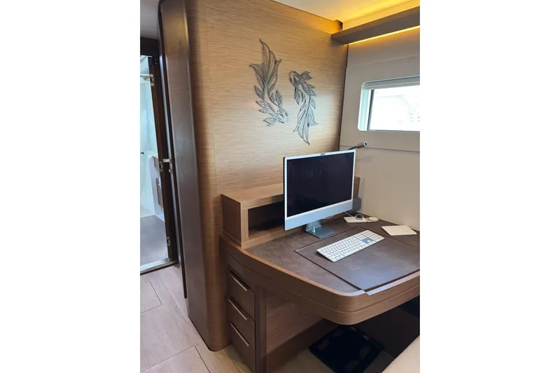  Yacht Photos Pics Modern workspace on 2020 Lagoon 46 yacht with computer and elegant wood finish.